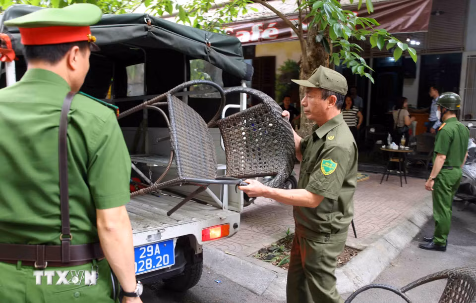 Tổ công tác phường Phương Liệt phát hiện và thu giữ vật dụng của một cơ sở kinh doanh dịch vụ ăn uống lấn chiếm vỉa hè trên phố Nguyễn Ngọc Nại. (Ảnh: Phạm Kiên/TTXVN)