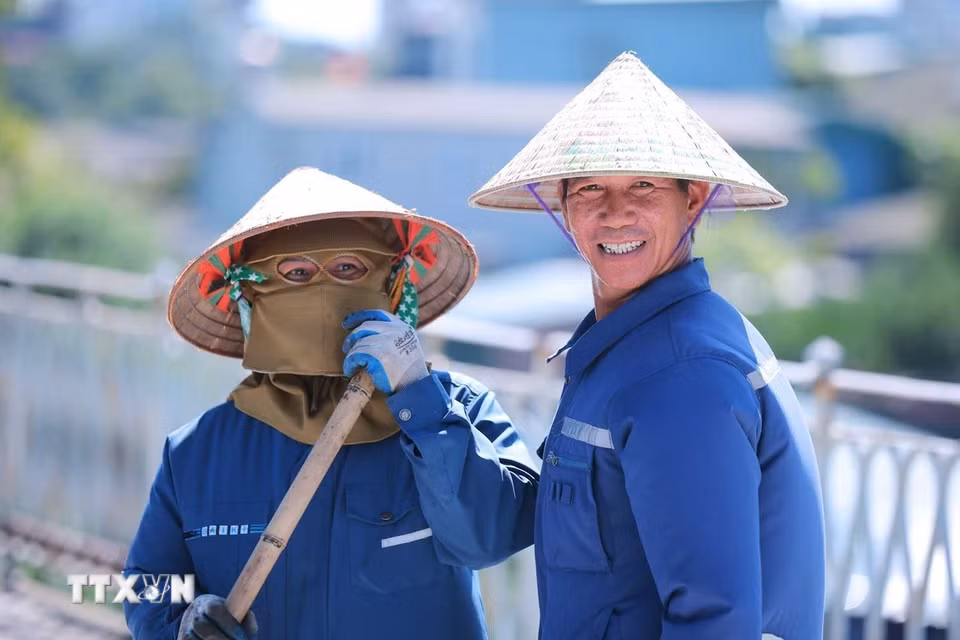 Những công nhân đang làm việc trên công trường cầu Long Biên trong cái nắng gay gắt giữa trưa 24/5. (Ảnh: Hoàng Hiếu/TTXVN)