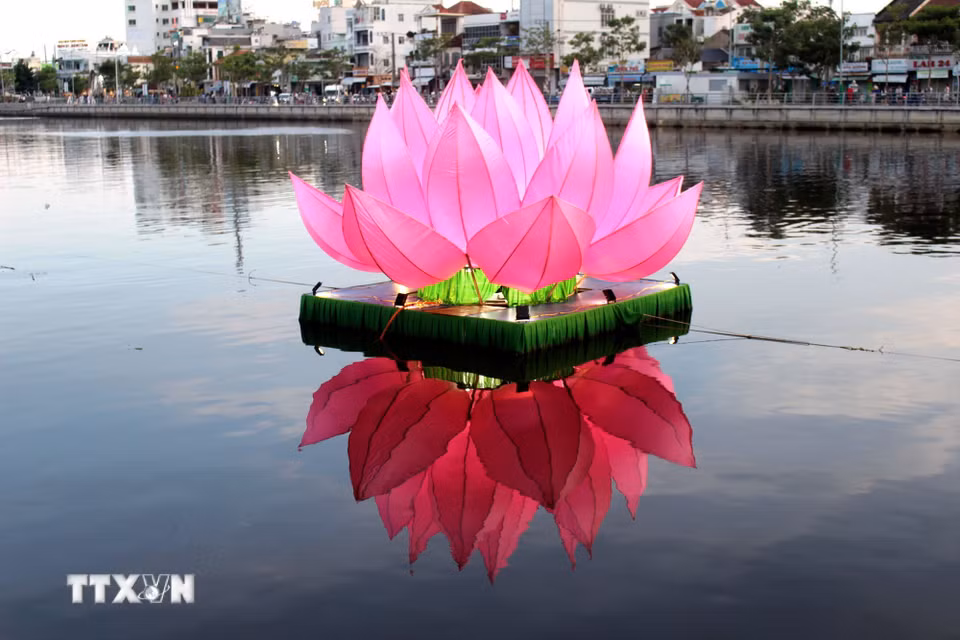 Mỗi đóa hoa sen được cố định bằng vật liệu nổi trên sông Cà Ty đảm bảo an toàn tàu thuyền đi lại. (Ảnh: Hồng Hiếu/TTXVN)