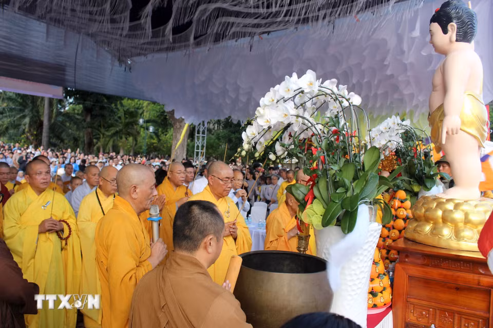 Nghi thức cúng Phật thắp sáng 7 đóa hoa sen. (Ảnh: Hồng Hiếu/TTXVN)