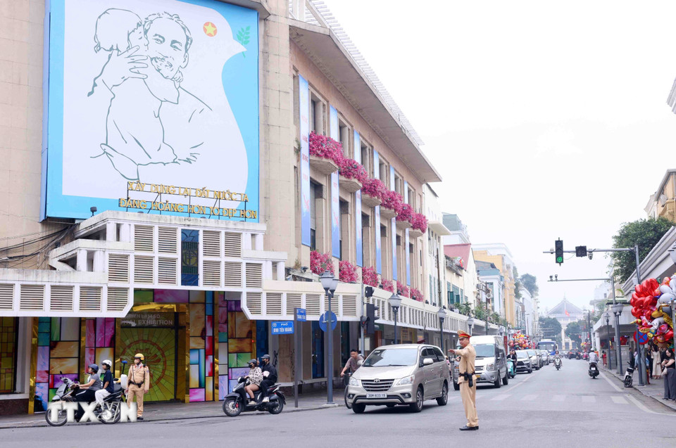 Lực lượng Cảnh sát giao thông điều tiết, phân luồng giao thông tại nút giao phố Tràng Tiền - Đinh Tiên Hoàng, Hà Nội trong sáng mùng 1 Tết. (Ảnh: Phạm Kiên/TTXVN)