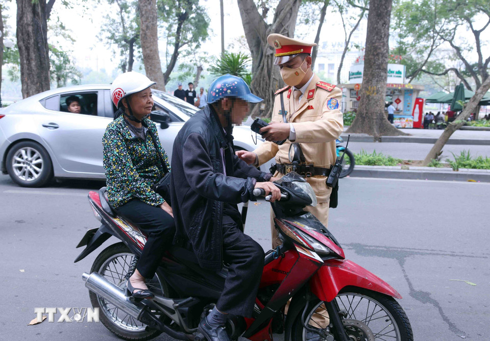 Cán bộ, chiến sỹ Đội Cảnh sát giao thông số 1, Công an Hà Nội kiểm tra nồng độ cồn với người tham gia giao thông vào sáng mùng 1 Tết. (Ảnh: Phạm Kiên/TTXVN)