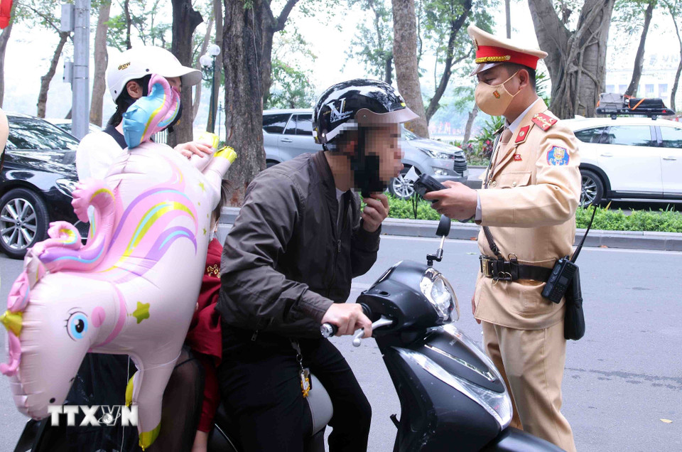 Cán bộ, chiến sỹ Đội Cảnh sát giao thông số 1, Công an Hà Nội kiểm tra nồng độ cồn với người tham gia giao thông vào sáng mùng 1 Tết. (Ảnh: Phạm Kiên/TTXVN)