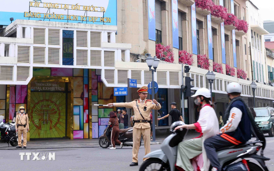 Lực lượng Cảnh sát giao thông điều tiết, phân luồng giao thông tại nút giao phố Tràng Tiền - Đinh Tiên Hoàng, Hà Nội trong sáng mùng 1 Tết. (Ảnh: Phạm Kiên/TTXVN)