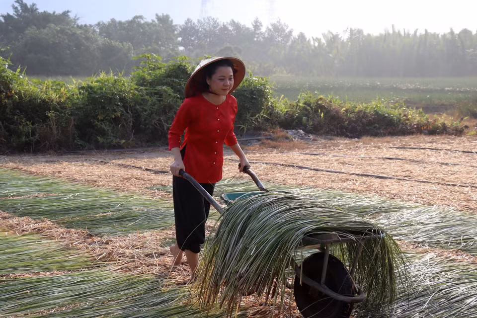 Chị Nguyễn Vũ Cẩm Ngân, ngụ xã Hậu Nghĩa trải nghiệm hoạt động nghề truyền thống. (Ảnh: Đức Hạnh/TTXVN)