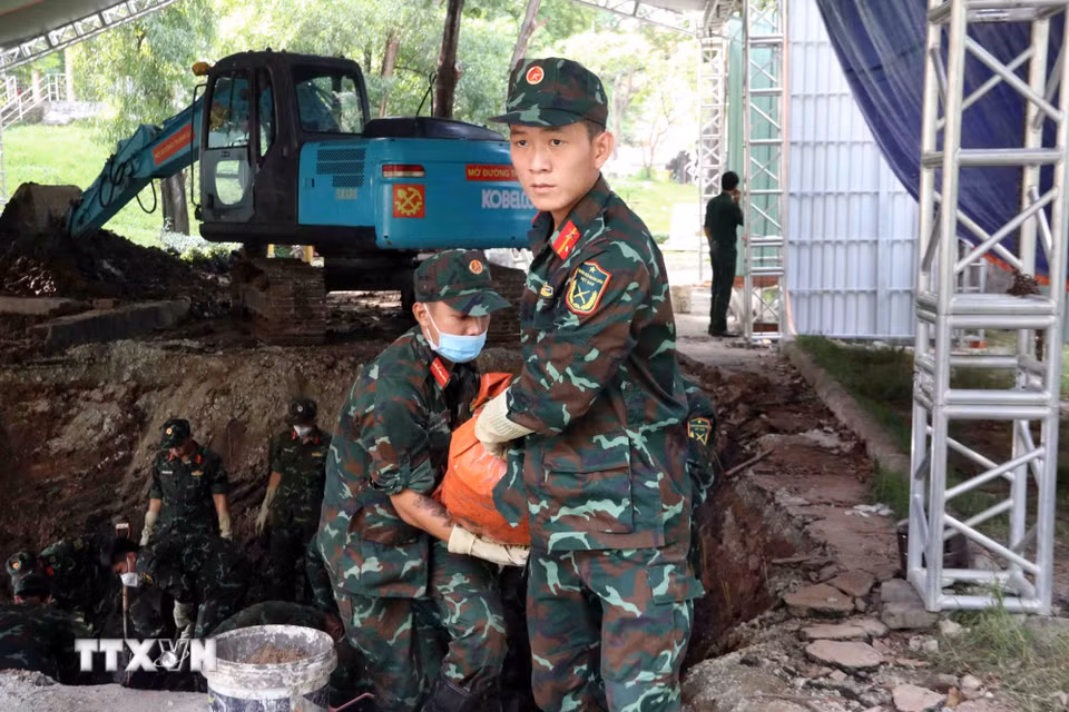 Lực lượng tìm kiếm, quy tập hài cốt liệt sỹ của Bộ Tư lệnh Thành phố Hồ Chí Minh cẩn trọng đưa hài cốt các anh hùng liệt sỹ khỏi hố đào về nơi thực hiện các quy trình tiếp theo. (Ảnh: Xuân Khu/TTXVN)
