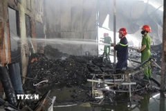 Lực lượng chức năng nỗ lực dập tắt đám cháy. (Ảnh: Nhựt An/TTXVN)