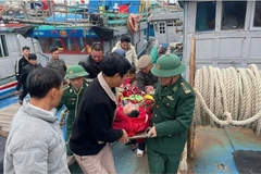 Cán bộ, chiến sỹ Đồn Biên phòng Quỳnh Phương và ngư dân vận chuyển nạn nhân lên tuyến trên điều trị. (Nguồn: Báo Nhân dân)