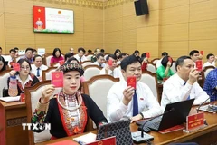 Đại biểu HĐND tỉnh Yên Bái biểu quyết thông qua Nghị quyết tại Kỳ họp. (Ảnh: TTXVN phát)