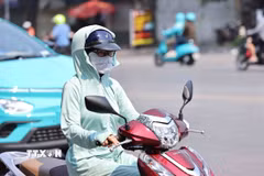 Mỗi khi phải ra đường, dù người lớn hay trẻ em đều dùng mọi biện pháp như khẩu trang hay áo chống nắng để chống lại cái nắng nóng gay gắt. (Ảnh: Minh Đức/TTXVN)