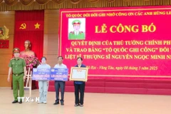 Thượng tá Trần Thanh Hiển, Phó Giám đốc Công an tỉnh Bà Rịa-Vũng Tàu trao Bằng Tổ quốc ghi công và kinh phí hỗ trợ cho thân nhân Liệt sỹ, Thượng sỹ Nguyễn Ngọc Minh Nhật. (Ảnh: Đoàn Mạnh Dương/TTXVN)