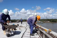 Giữa trưa nắng nóng như đổ lửa, các công nhân vẫn khẩn trương thi công các hạng mục phụ để sớm thông xe kỹ thuật cầu Đại Ngãi 2 dịp lễ 30/4. (Ảnh: Trung Hiếu/TTXVN)