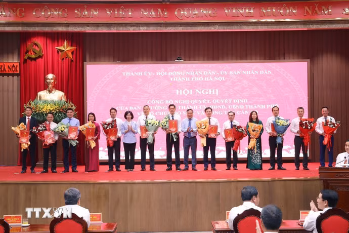 Chủ tịch Hội đồng Nhân dân thành phố Hà Nội Phùng Thị Hồng Hà và Phó Bí thư Thành ủy Hà Nội Nguyễn Văn Phong trao các quyết định của Ban Thường vụ Thành ủy Hà Nội cho các đồng chí. (Ảnh: Văn Điệp/TTXVN)