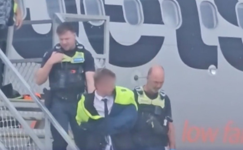 Thiếu niên bị khống chế và đưa khỏi máy bay (Nguồn: X)