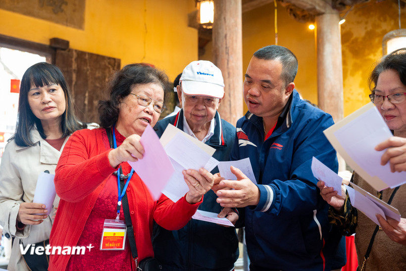 Các cử tri đến bỏ phiếu được thành viên tổ bầu cử hướng dẫn tận tình. (Ảnh: Minh Sơn/Vietnam+)