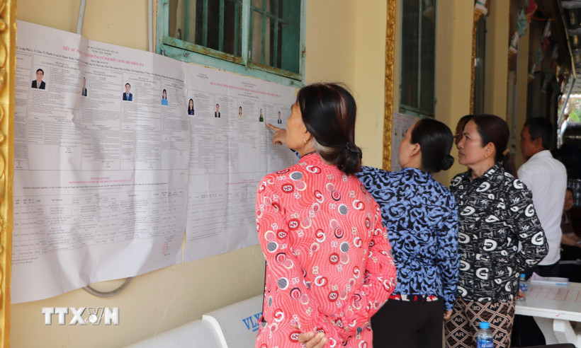 Đồng bào Khmer ấp Ngã Cạy, xã Xà Phiên tìm hiểu thông tin về ứng cử viên đại biểu Quốc hội và Hội đồng Nhân dân được niêm yết tại chùa Bôrâysarâychum. (Ảnh: Hồng Thái/TTXVN)