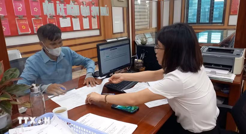 Hướng dẫn người dân làm thủ tục hành chính. (Ảnh: Nguyễn Chinh/TTXVN)