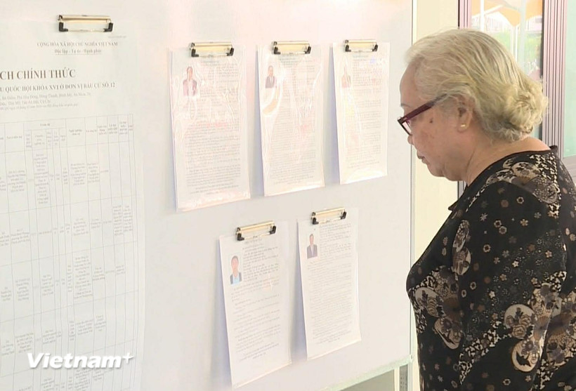 Tại các khu vực bỏ phiếu, lý lịch trích ngang của các ứng viên đều được niêm yết công khai, tiện cho cử tri nghiên cứu trước khi đưa ra quyết định cho lá phiếu của mình. (Ảnh: Hữu Duyên/Vietnam+)