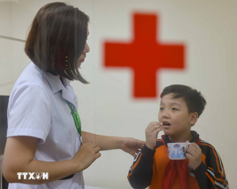 Nhân viên y tế học đường chăm sóc học sinh. (Ảnh: Thanh Tùng/TTXVN)