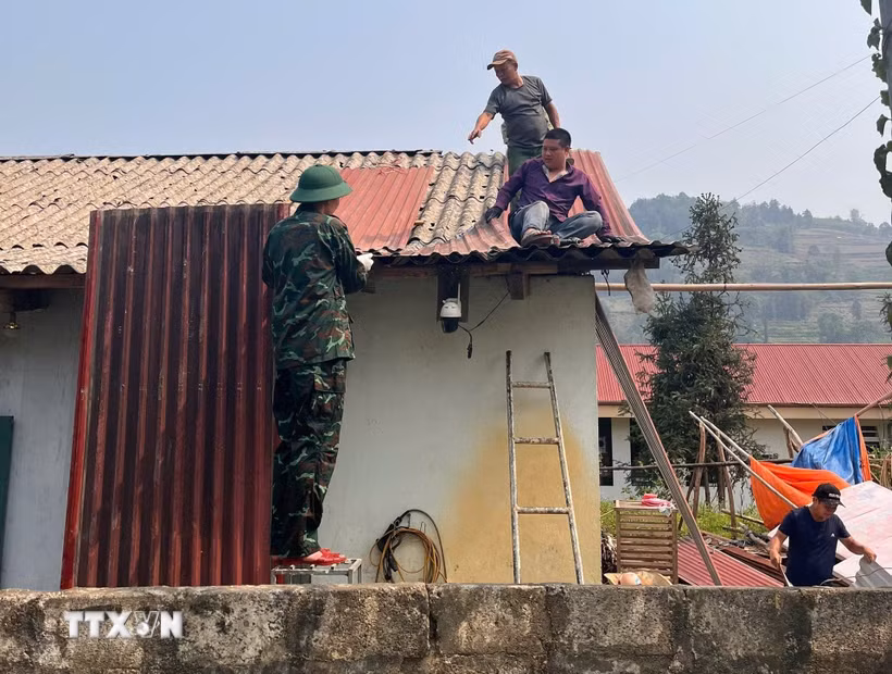 Cán bộ, chiến sỹ Bộ Chỉ huy quân sự tỉnh Lào Cai giúp bà con xã Bắc Hà lợp lại mái nhà, nhanh chóng ổn định cuộc sống sau trận mưa đá. (Ảnh: TTXVN phát)