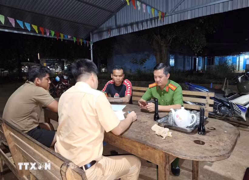 Lực lượng Cảnh sát giao thông lập biên bản xử lý các đối tượng dàn hàng ngang, bốc đầu xe máy trên đường vành đai Trảng cỏ Bù Lạch. (Ảnh: TTXVN phát)