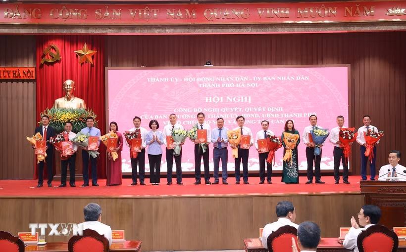 Chủ tịch Hội đồng Nhân dân thành phố Hà Nội Phùng Thị Hồng Hà và Phó Bí thư Thành ủy Hà Nội Nguyễn Văn Phong trao các quyết định của Ban Thường vụ Thành ủy Hà Nội cho các đồng chí. (Ảnh: Văn Điệp/TTXVN)