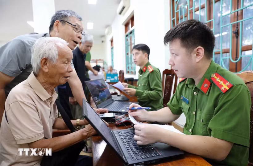 Cán bộ, chiến sỹ phòng PC06 lấy thông tin của thân nhân liệt sỹ tại địa bàn phường Điện Biên Phủ. (Ảnh: Trung Kiên/TTXVN)
