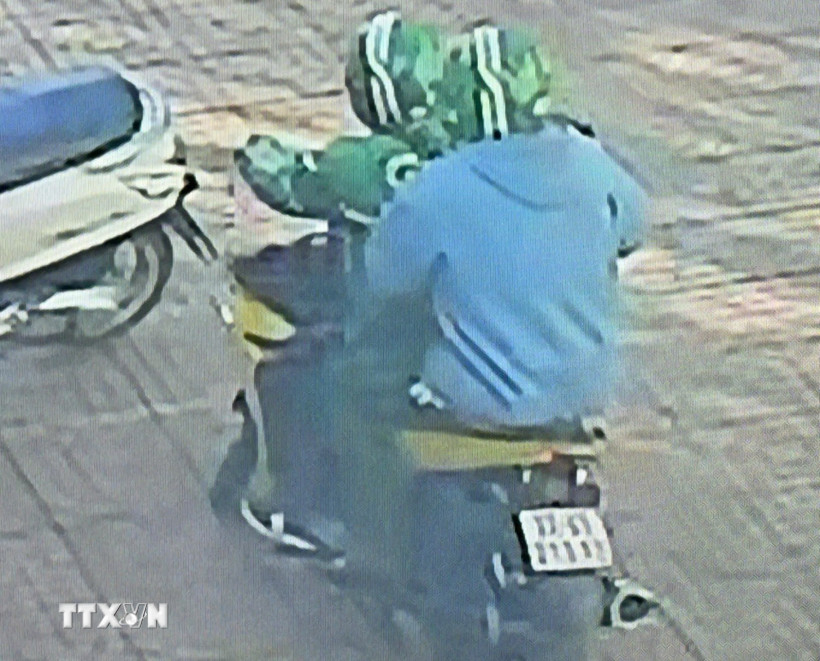 Các đối tượng dùng súng cướp ngân hàng. (Ảnh chụp màn hình camera. TTXVN phát)