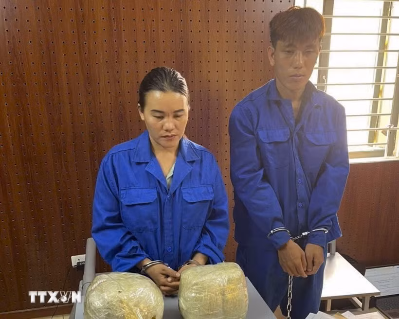 Hai đối tượng Bàn Sành Quang và Chảo Tả Mẩy cùng tang vật bị bắt giữ. (Ảnh: TTXVN phát)