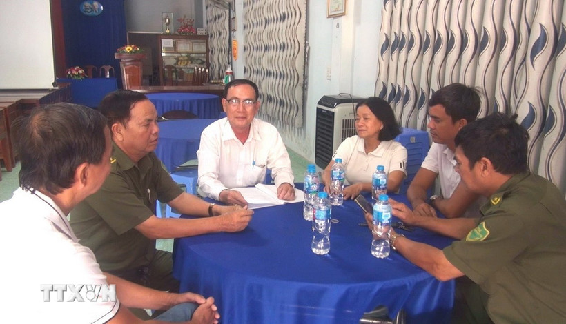 Ông Nguyễn Hoài Trung, Bí thư Chi bộ, Trưởng khu phố 3, xã Đức Hòa, tỉnh Tây Ninh đang trao đổi cùng tổ an ninh tự quản. (Ảnh: Thanh Bình/TTXVN)