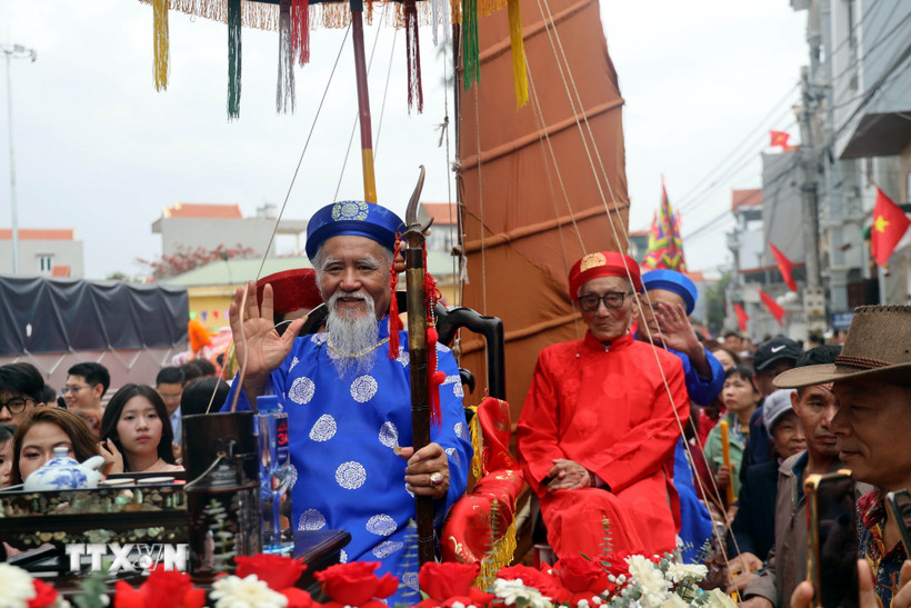 Cụ ông Vũ Văn Oanh (hàng đầu áo xanh), phường Phong Cốc, tỉnh Quảng Ninh, tròn 80 tuổi và được con cháu rước lên miếu Tiên Công. (Ảnh: Đức Hiếu/TTXVN)