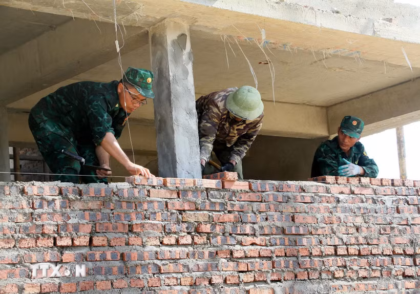 Cán bộ chiến sỹ Bộ đội biên phòng Nghệ An tích cực tham gia xây dựng Trường Phổ thông Dân tộc nội trú liên cấp Tiểu học và Trung học cơ sở Anh Sơn. (Ảnh: Văn Tý/TTXVN)