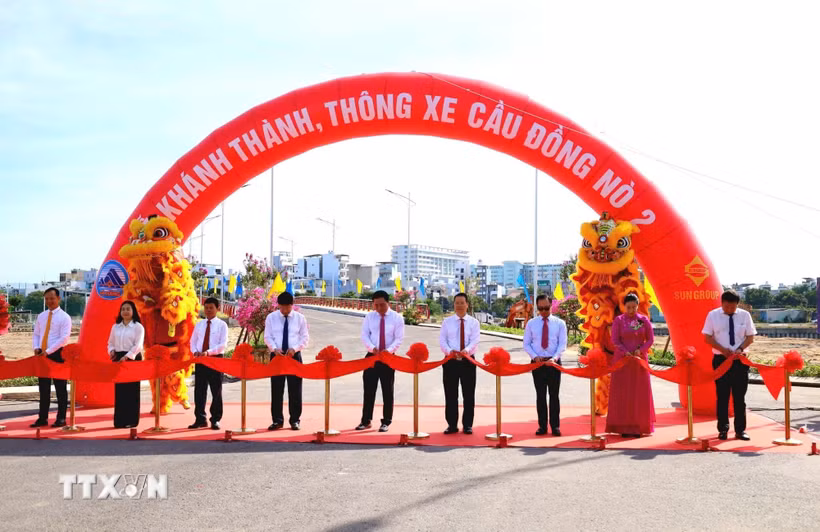 Đại biểu thực hiện nghi thức cắt băng khánh thành cầu Đồng Nò 2. (Ảnh: Trần Lê Lâm/TTXVN)