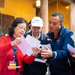 Các cử tri đến bỏ phiếu được thành viên tổ bầu cử hướng dẫn tận tình. (Ảnh: Minh Sơn/Vietnam+)