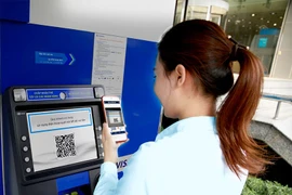 Khách hàng rút tiền nhanh bằng QR tại ATM. (Ảnh: Vietnam+)