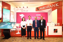 Phó Tổng Giám đốc Agribank Lê Hồng Phúc thăm gian hàng Agribank trong khuôn khổ diễn đàn. (Ảnh: Vietnam+)