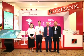 Phó Tổng Giám đốc Agribank Lê Hồng Phúc thăm gian hàng Agribank trong khuôn khổ diễn đàn. (Ảnh: Vietnam+)