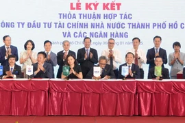 Đại diện Sacombank – ông Huỳnh Thiên Phú (Giám đốc Trung tâm phát triển kinh doanh Doanh nghiệp) cùng các ngân hàng thực hiện ký kết hợp tác với HFIC. (Ảnh: Vietnam+)