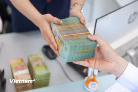 Ngân hàng nỗ lực giảm mặt bằng lãi suất hỗ trợ thúc đẩy tăng trưởng. (Ảnh: Vietnam+)
