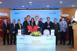 Ông Lê Quang Vinh – Thành viên HĐQT, Tổng Giám đốc Vietcombank (bên phải) và ông Đặng Chính Trung – Thành viên HĐQT, Tổng Giám đốc IDICO (bên trái) đại diện hai đơn vị hoàn thành nghi thức ký kết thỏa thuận hợp tác trước sự chứng kiến của các đại biểu. (Ảnh: Vietnam+)