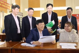 Tổng Giám đốc Ngân hàng Chính sách xã hội Dương Quyết Thắng trao đổi với Tổ trưởng Tổ tiết kiệm và vay vốn tại phiên giao dịch định kỳ hàng tháng của Ngân hàng Chính sách xã hội tại xã Phong Niên, huyện Bảo Thắng. (Ảnh: Vietnam+)