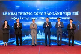 Thứ trưởng Bộ Y tế Trần Văn Thuấn, Cục trưởng Cục Quản lý Khám, chữa bệnh Hà Anh Đức, Giám đốc Sở Y tế thành phố Hồ Chí Minh Tăng Chí Thượng, Giám đốc Bệnh viện Đa khoa Hà Đông Nguyễn Thành Vinh cùng TGĐ Ngân hàng TMCP Sài Gòn - Hà Nội Ngô Thu Hà, đại diện CTCP Phát triển Công nghệ Thẻ Việt bấm nút Khai trương Cổng bảo lãnh viện phí. (Ảnh: Vietnam+)