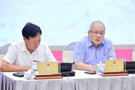 Ông Đỗ Thành Trung - Thứ trưởng Bộ Tài chính (bên phải) trả lời báo chí tại họp báo Chính phủ. (Ảnh: Vietnam+)
