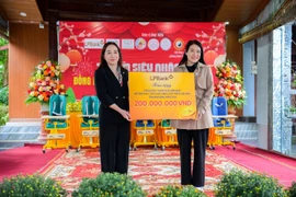 Bà Nguyễn Thị Vui, thành viên Ban điều hành (trái) đại diện LPBank trao tặng 200 triệu đồng cho chương trình. (Ảnh: Vietnam+)