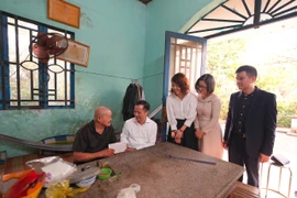 Ông Lê Hoàng Tùng - Phó Tổng Giám đốc Vietcombank, bà Lê Thị Thu Hà - Phó Chủ tịch thường trực Công đoàn Vietcombank và đại diện ngân hàng đến thăm hỏi, động viên cựu chiến binh Châu Văn Đực tại gia đình. (Ảnh: Vietnam+)