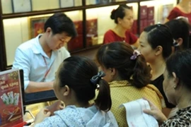 Khách hàng giao dịch vàng. (Ảnh: Vietnam+)
