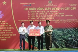 Thiếu tướng Đinh Văn Nơi - Cục trưởng Cục An ninh chính trị nội bộ, Bộ Công an (ngoài cùng bên phải) và ông Lê Hoàng Tùng – Phó Tổng Giám đốc Vietcombank (ngoài cùng bên trái) trao bảng tượng trưng số tiền tài trợ xây dựng 4 cầu giao thông nông thôn tặng huyện Giồng Trôm, tỉnh Bến Tre. (Ảnh: Vietnam+)