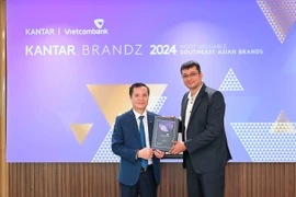 Đại diện Vietcombank, ông Lê Hoàng Tùng - Phó Tổng Giám đốc (bên trái) nhận chứng nhận “Top 30 thương hiệu giá trị nhất Đông Nam Á” từ đại diện Kantar, ông Sumit Kamra - Giám đốc Phát triển Chiến lược Kantar Insights. (Ảnh: Vietnam+)
