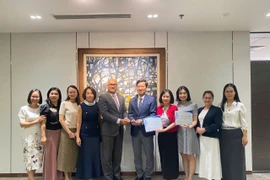 Đại diện Vietcombank, ông Vũ Quang Đông - Phó Giám đốc Khối phụ trách điều hành Khối vốn & Thị trường (đứng thứ 5 từ phải sang) nhận giải thưởng từ đại diện Ngân hàng J.P. Morgan Chase, ông Madhav Kalyan - Giám đốc Điều hành phụ trách Khối Dịch vụ thanh toán Khu vực Châu Á - Thái Bình Dương. (Ảnh: Vietnam+)