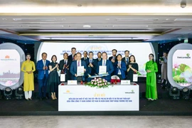 Ông Lê Quang Vinh - Thành viên Hội đồng quản trị, Tổng Giám đốc Vietcombank (bên phải) và ông Lê Hồng Hà - Thành viên Hội đồng quản trị kiêm Tổng Giám đốc Vietnam Airlines (bên trái) đại diện hai đơn vị hoàn thành nghi thức ký kết biên bản ghi nhớ trước sự chứng kiến của các đại biểu. (Ảnh: Vietnam+) 
